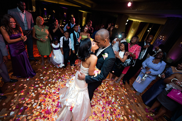 bride and groom kissing in the middle of dance floor after thire first dance surrounded by a pile of rose petals - photo by Houston based wedding photographer Adam Nyholt